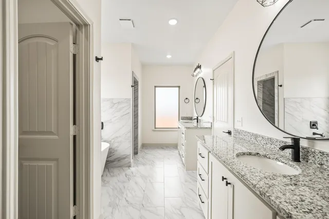 a spacious bathroom with a granite countertop sink mirror and shower