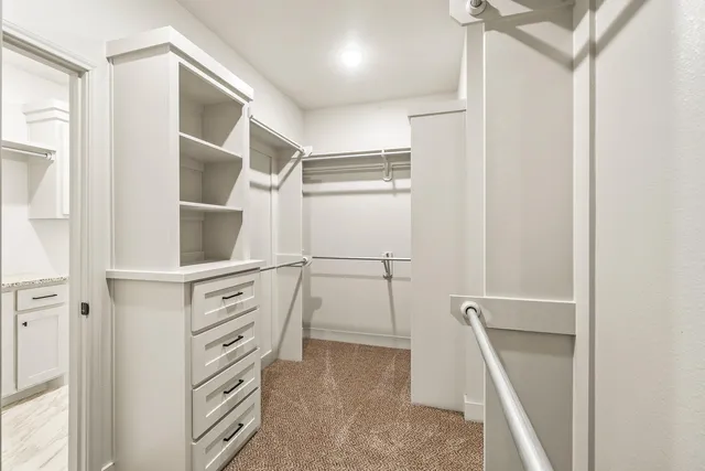 a view of walk in closet with empty racks