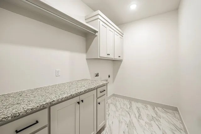 a kitchen with granite countertop white cabinets and a wooden floor