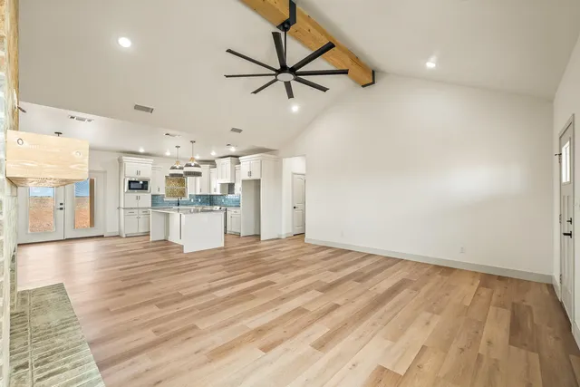 a view of empty room with wooden floor and windows