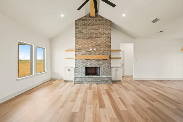 a view of empty room with wooden floor and fireplace