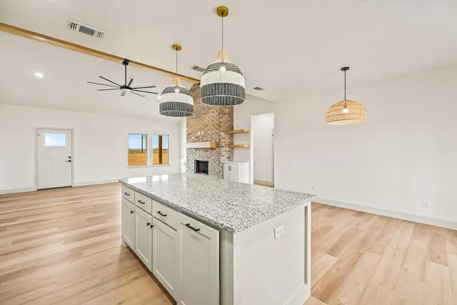 a kitchen with stainless steel appliances granite countertop a stove a sink and a wooden floors