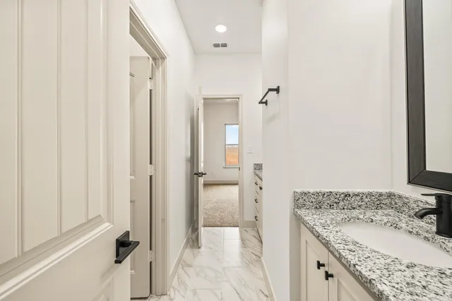 an empty room with a fan & a window