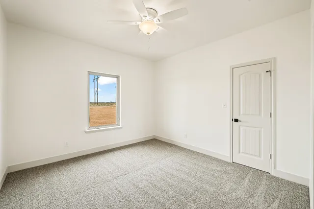 an empty room with fan and entryway