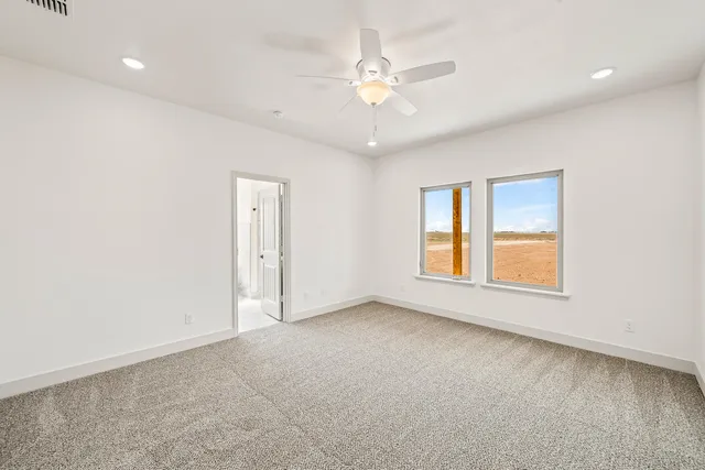 an empty room with chandelier fan