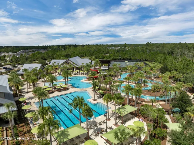 a backyard of a house with table and chairs plants and large tree