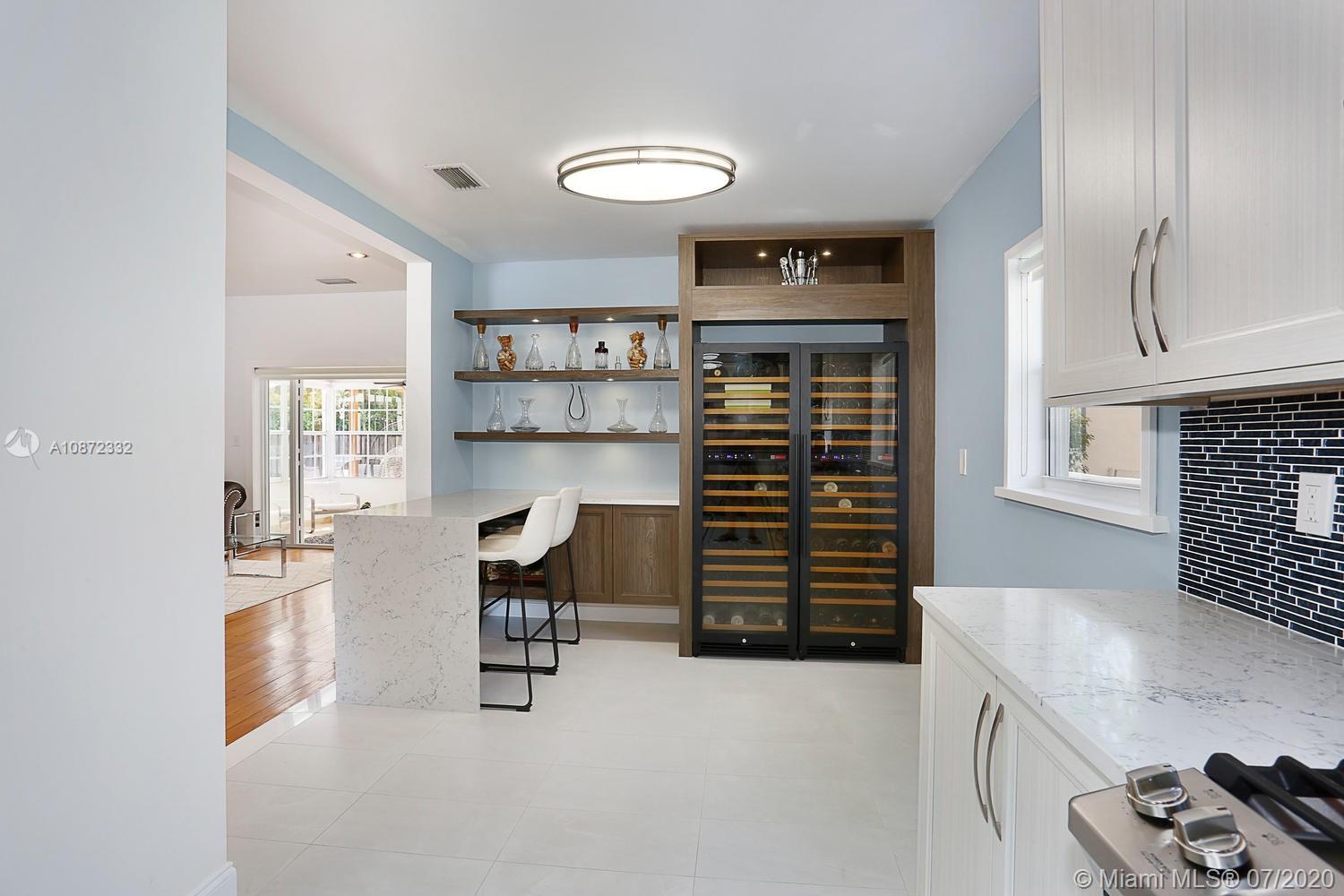 5161 Alton Road Miami Beach, FL 33140 - Photo 12 of 25 a kitchen with a refrigerator and a sink
