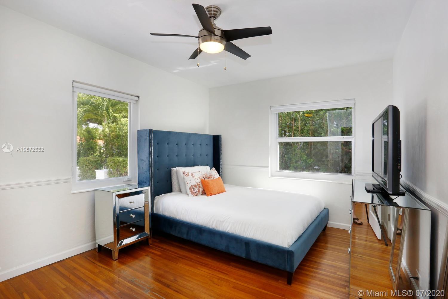 5161 Alton Road Miami Beach, FL 33140 - Photo 17 of 25 a bedroom with a bed a flat screen tv and a window