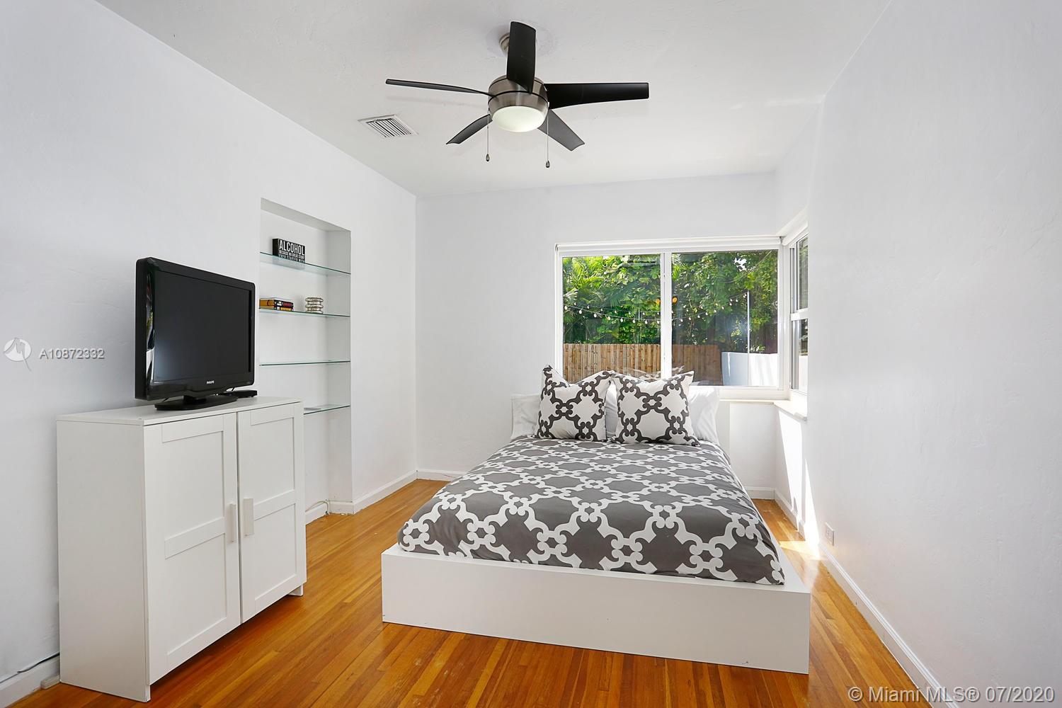 5161 Alton Road Miami Beach, FL 33140 - Photo 19 of 25 a living room with furniture and a flat screen tv