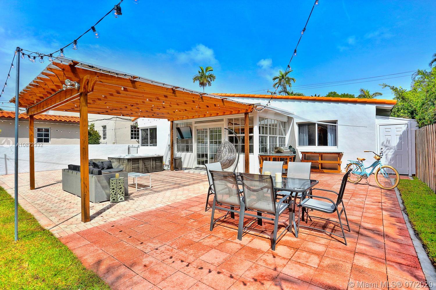 5161 Alton Road Miami Beach, FL 33140 - Photo 20 of 25 a view of a patio with table and chairs with wooden floor and fence