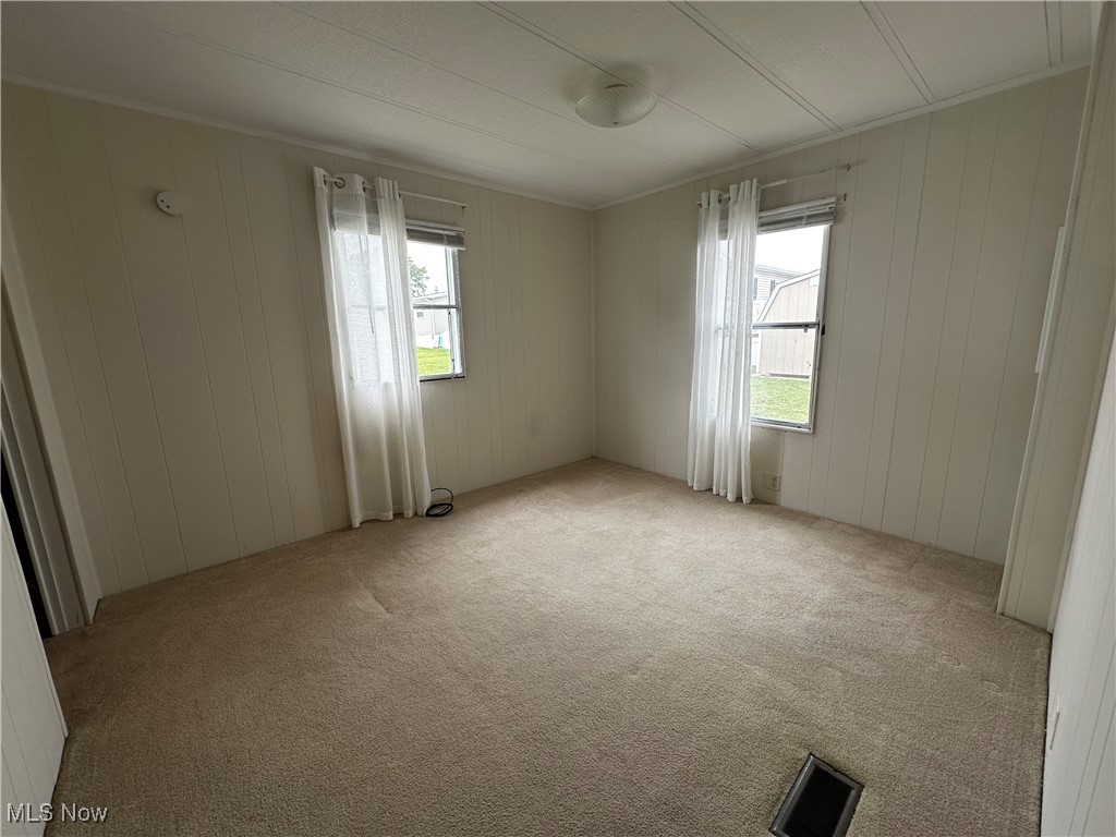 12921 Springfield Road, Unit 12S New Springfield, OH 44443 - Photo 12 of 25 Empty room with crown molding and light colored carpet