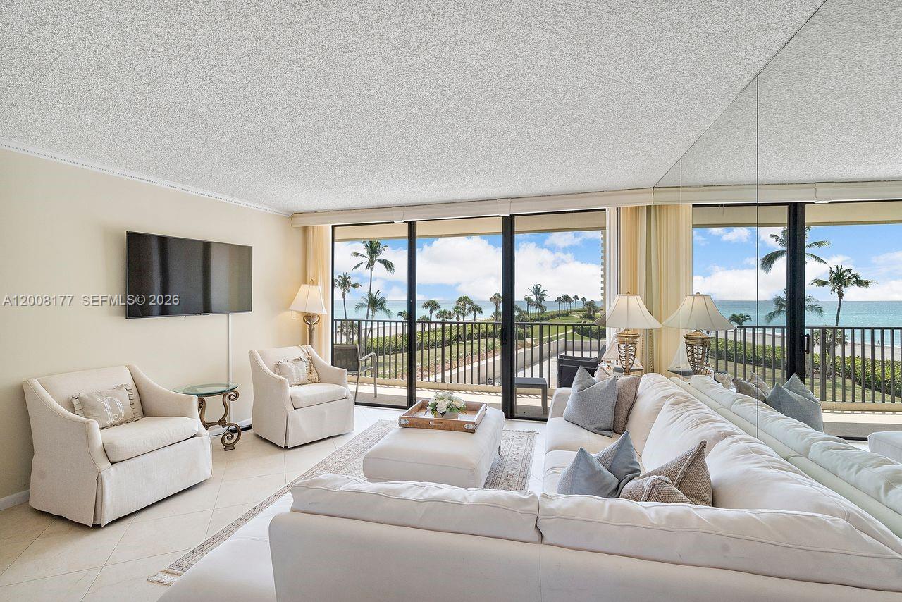 400 Ocean Trail Way, Unit 302 Jupiter, FL 33477 - Photo 13 of 29 a living room with furniture and a floor to ceiling window