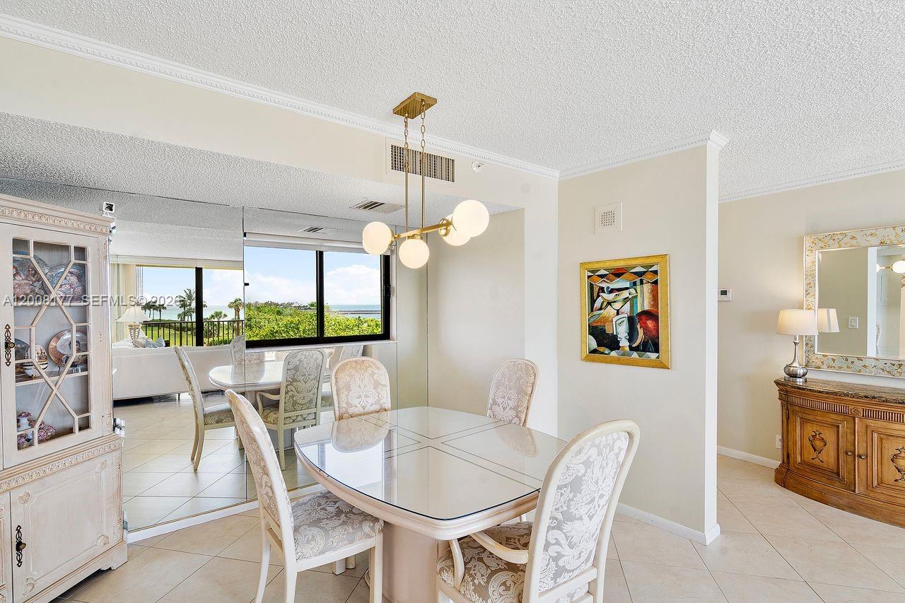 400 Ocean Trail Way, Unit 302 Jupiter, FL 33477 - Photo 14 of 29 a dining room with furniture a large window and a chandelier