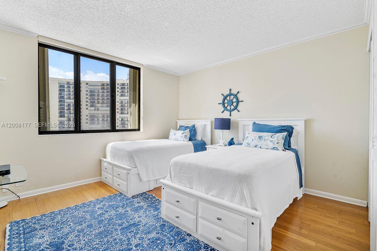 400 Ocean Trail Way, Unit 302 Jupiter, FL 33477 - Photo 18 of 29 a bedroom with two beds and a potted plant