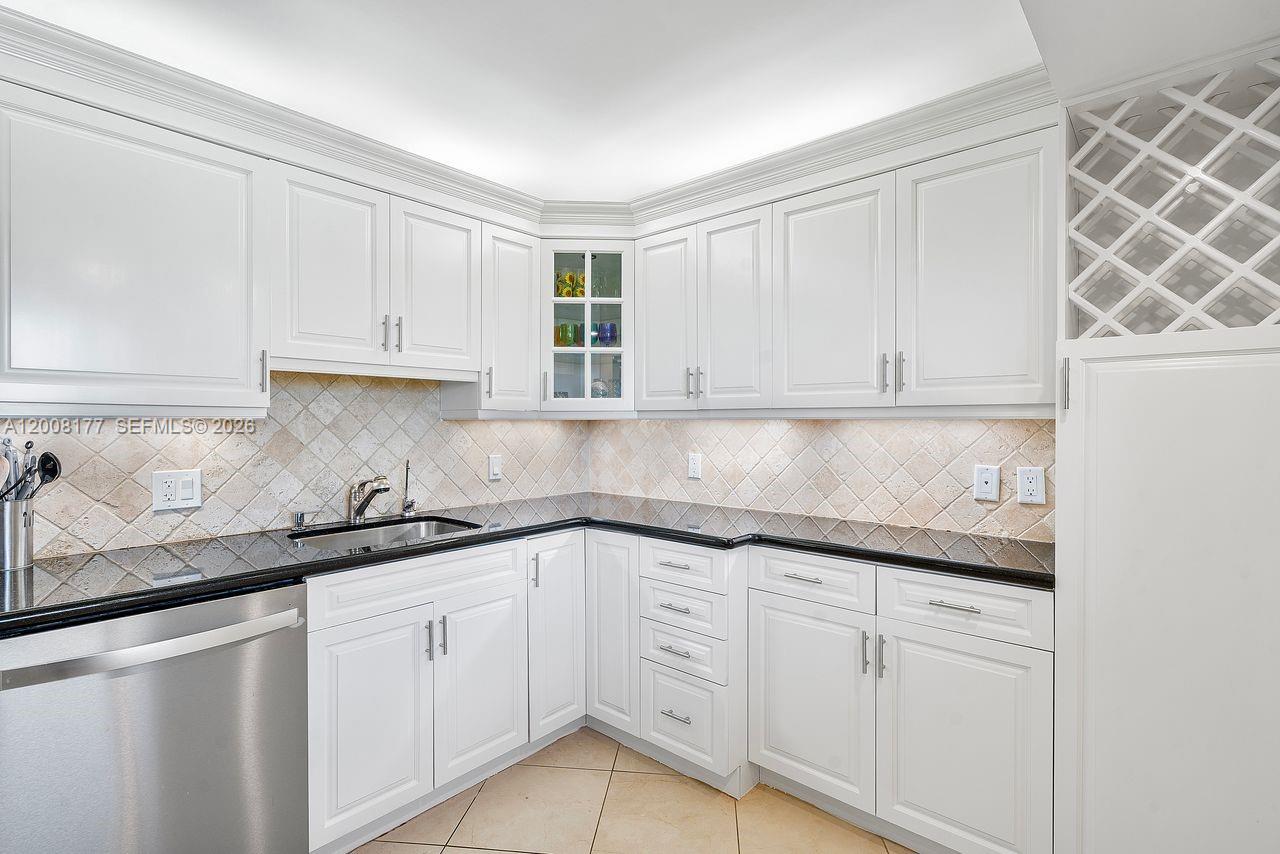 400 Ocean Trail Way, Unit 302 Jupiter, FL 33477 - Photo 2 of 29 a kitchen with granite countertop white cabinets and white appliances