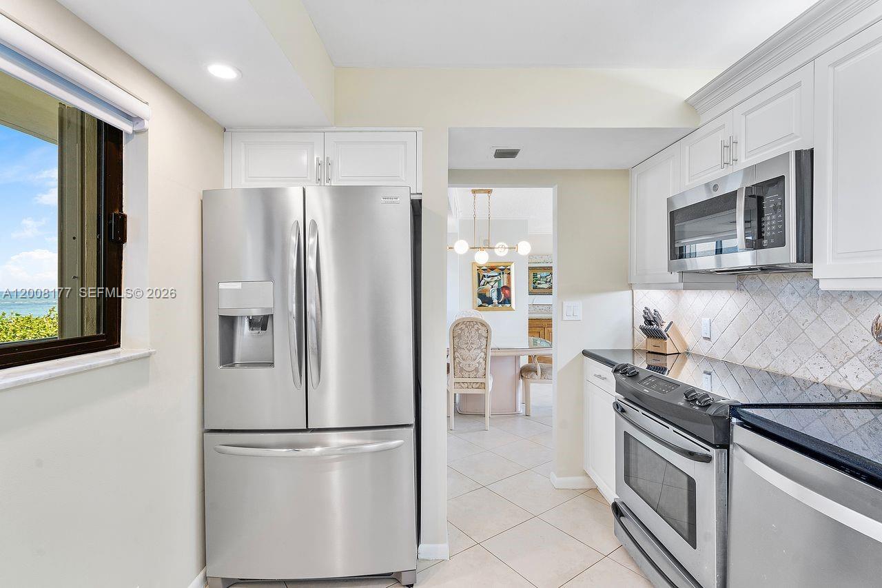 400 Ocean Trail Way, Unit 302 Jupiter, FL 33477 - Photo 4 of 29 a kitchen with stainless steel appliances granite countertop a refrigerator stove and microwave