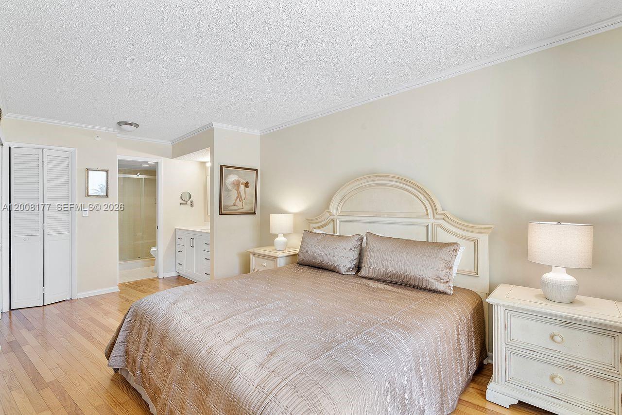 400 Ocean Trail Way, Unit 302 Jupiter, FL 33477 - Photo 8 of 29 a bedroom with a bed and a lamp