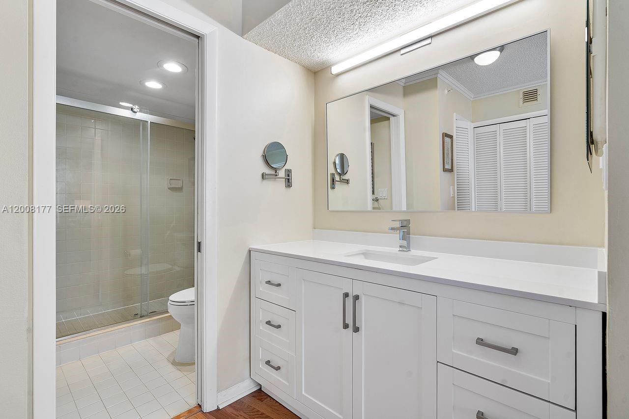 400 Ocean Trail Way, Unit 302 Jupiter, FL 33477 - Photo 9 of 29 a bathroom with a double vanity sink toilet and shower