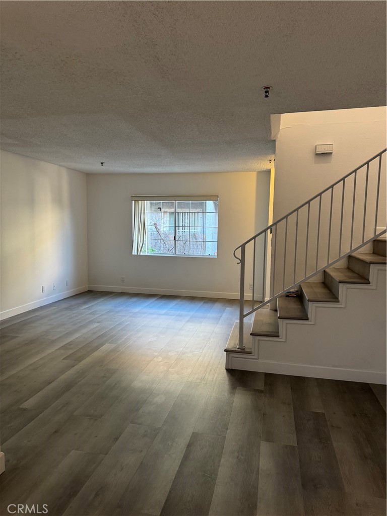1820 Pepper Street, Unit E Alhambra, CA 91801 - Photo 7 of 30 a view of an empty room with wooden floor and a window