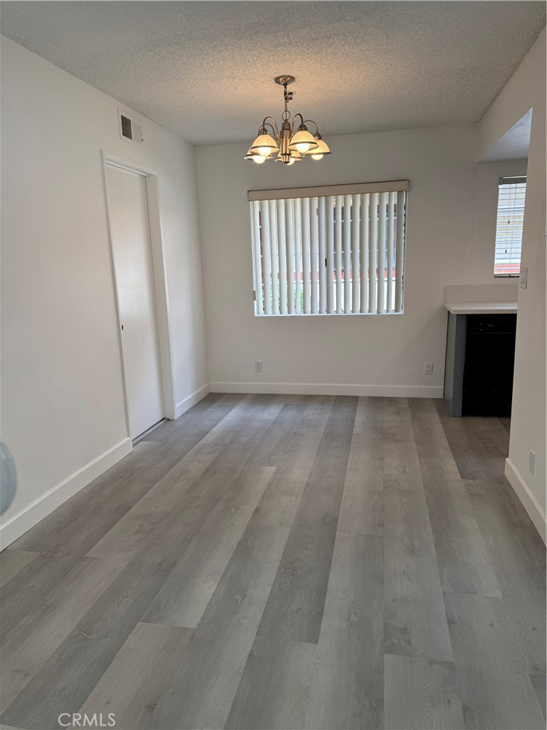 1820 Pepper Street, Unit E Alhambra, CA 91801 - Photo 9 of 30 an empty room with windows and a chandelier
