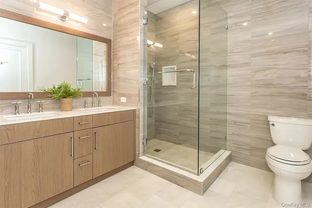 a bathroom with a shower sink mirror and toilet