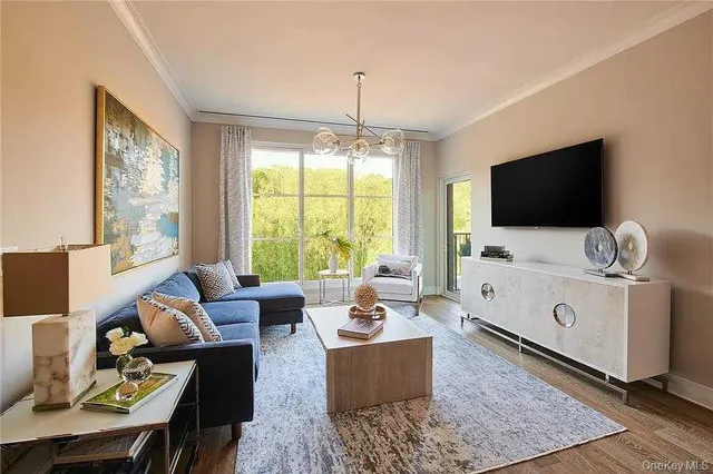a living room with furniture a flat screen tv and a floor to ceiling window