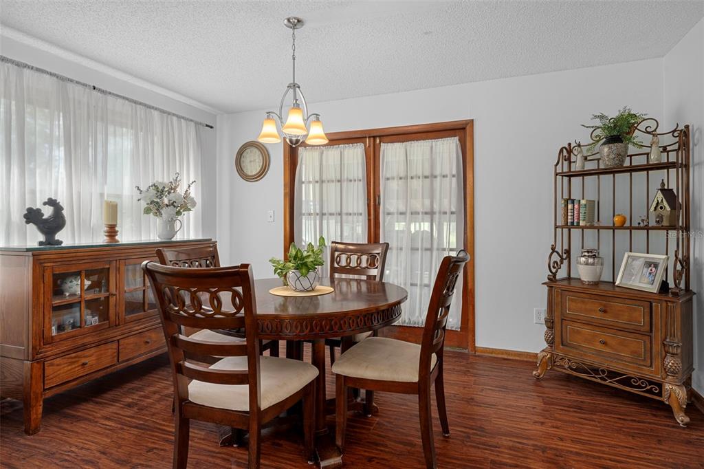 8605 Fussell Drive Wesley Chapel, FL 33545 - Photo 23 of 99 a dining room with furniture a chandelier and wooden floor