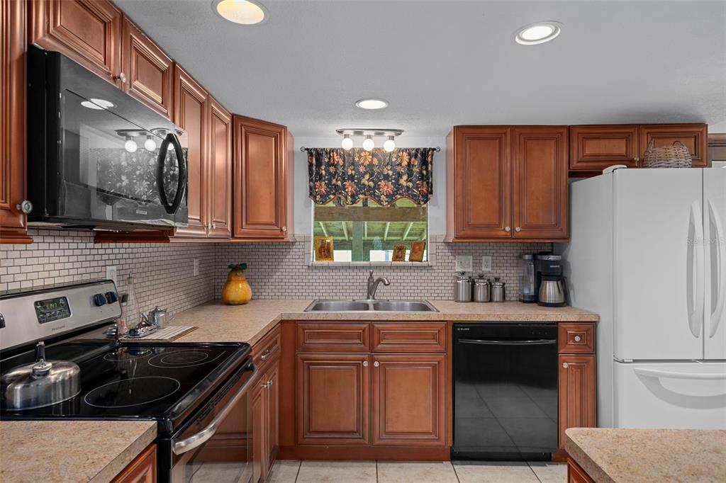 8605 Fussell Drive Wesley Chapel, FL 33545 - Photo 27 of 99 a kitchen with a sink a stove and cabinets