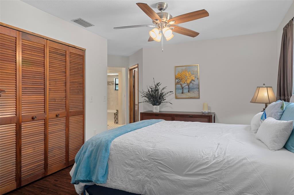 8605 Fussell Drive Wesley Chapel, FL 33545 - Photo 52 of 99 a bedroom with a large bed and a chandelier