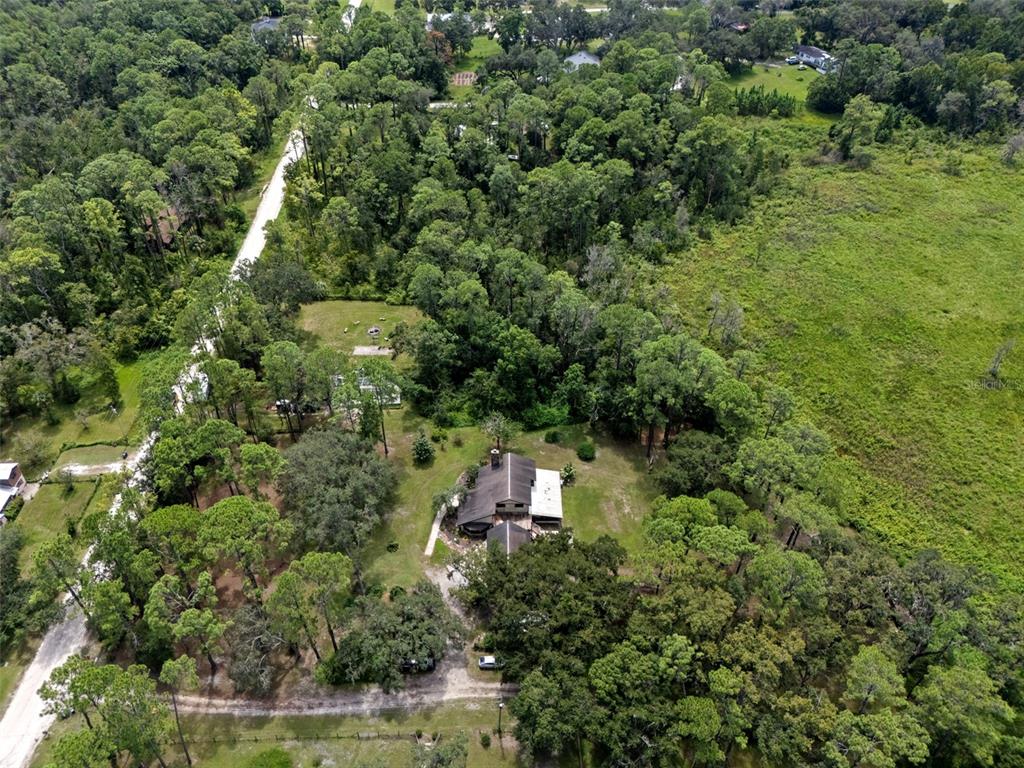 8605 Fussell Drive Wesley Chapel, FL 33545 - Photo 6 of 99 an aerial view of residential house with outdoor space and trees all around