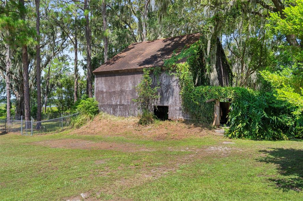 8605 Fussell Drive Wesley Chapel, FL 33545 - Photo 72 of 99 a backyard of a house with table and chairs under an umbrella