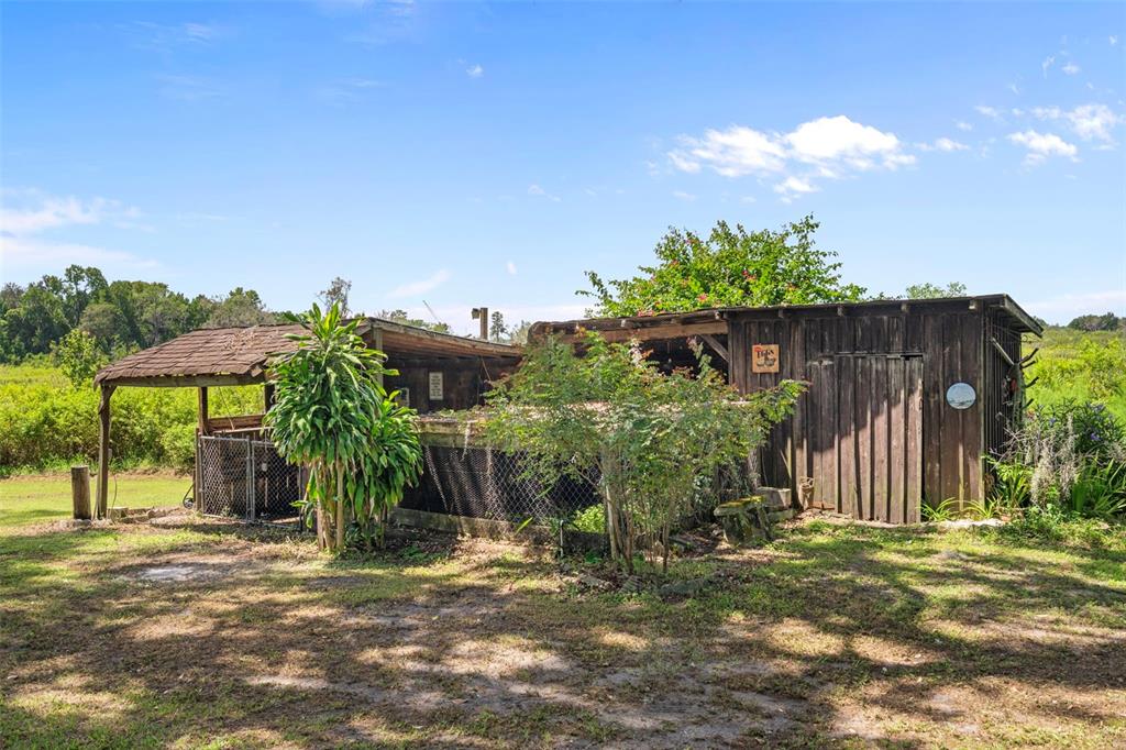 8605 Fussell Drive Wesley Chapel, FL 33545 - Photo 80 of 99 a backyard of a house with table and chairs under an umbrella