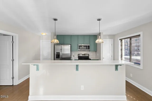 a kitchen with stainless steel appliances kitchen island sink refrigerator and microwave