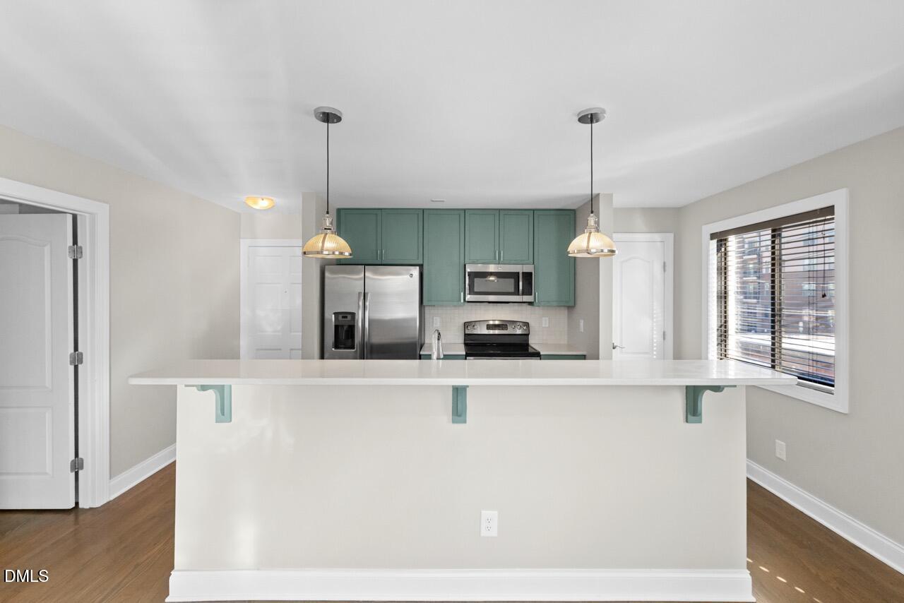 a kitchen with stainless steel appliances kitchen island sink refrigerator and microwave