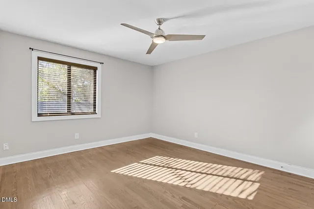 a view of a room with wooden floor and ceiling fan