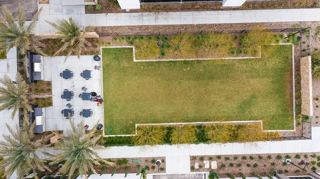 an aerial view of residential houses with outdoor space and parking