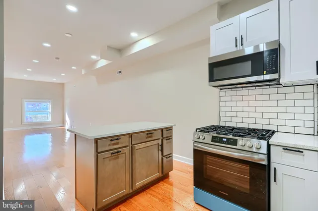 a kitchen with granite countertop a stove and a microwave