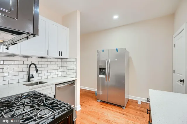 a kitchen with granite countertop a sink stove and refrigerator