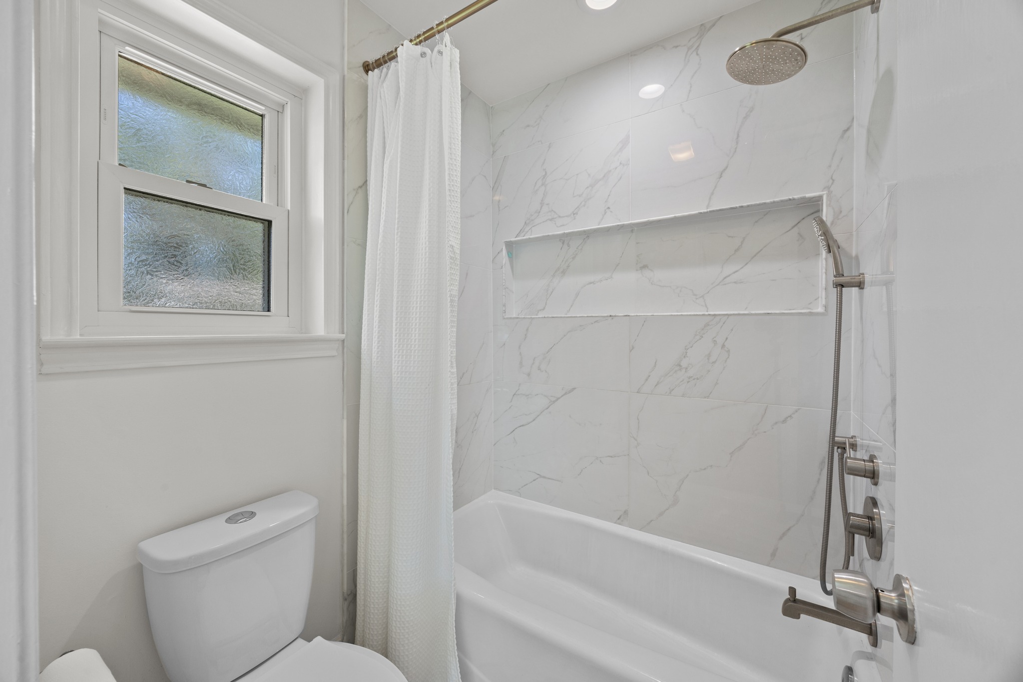 11019 Southwest Oaks Austin, TX 78737 - Photo 19 of 39 The bathroom remodel included an opulent tile surround and a dual showerhead with rain option.