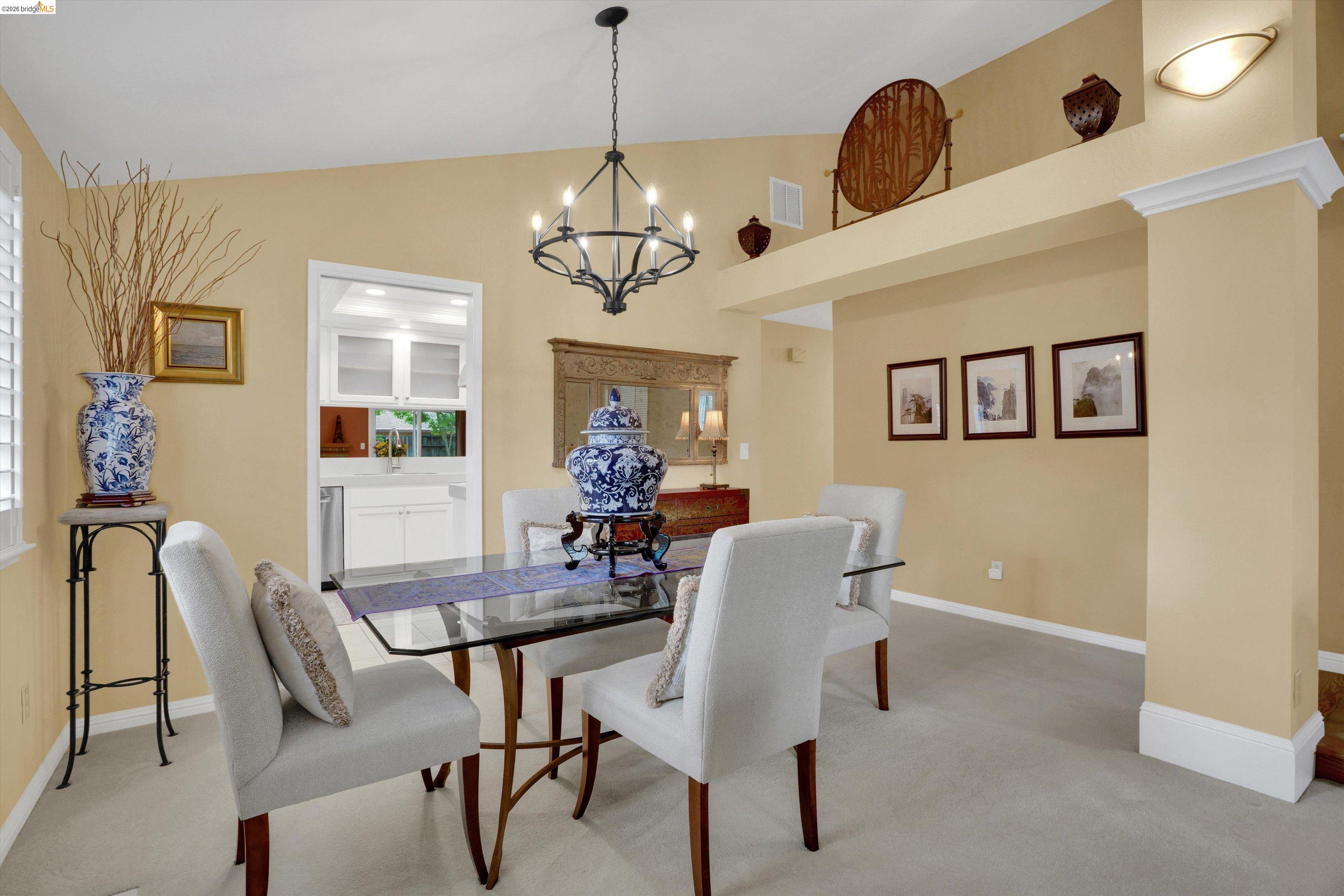 5001 St Garrett Court Concord, CA 94521 - Photo 16 of 45 Dining area with vaulted ceiling, featuring a chandelier, a pass-through opening, and a decorative ledge