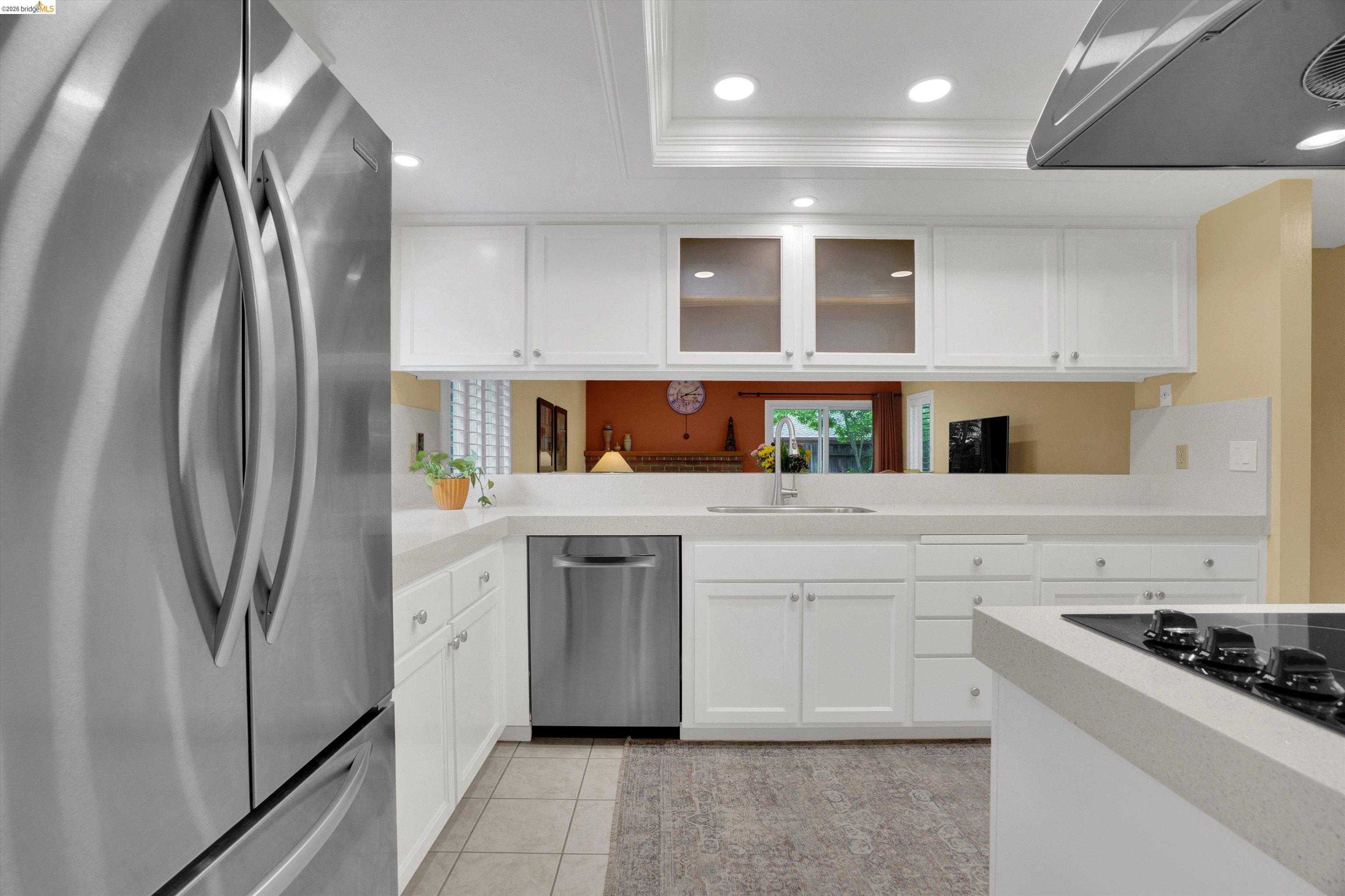 5001 St Garrett Court Concord, CA 94521 - Photo 19 of 45 Kitchen featuring white cabinetry, stainless steel appliances, a built-in cooktop, and light-toned countertops