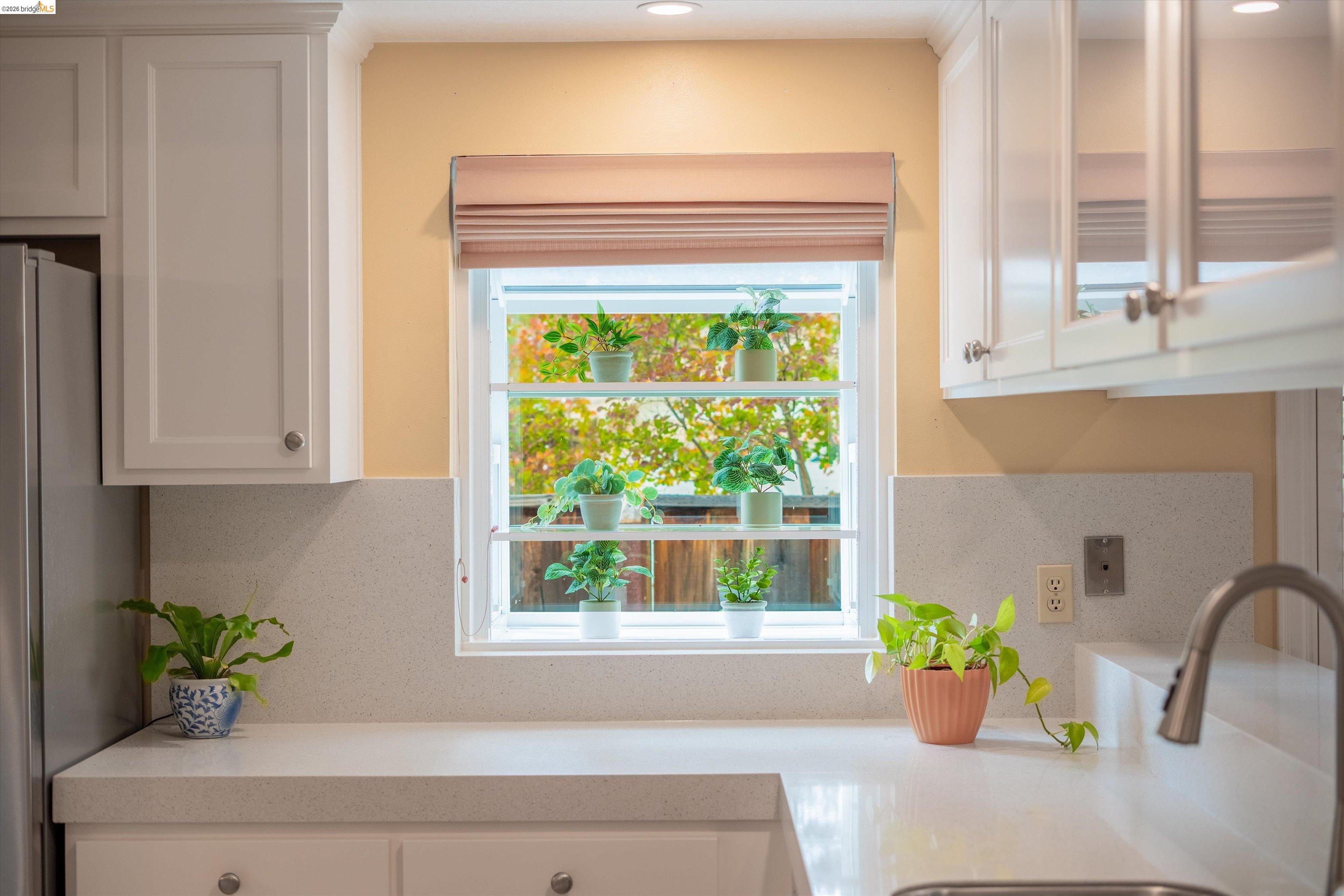 5001 St Garrett Court Concord, CA 94521 - Photo 2 of 45 Kitchen featuring white cabinetry with silver hardware, light-colored countertops, a single-basin sink with a gooseneck faucet, and a window with a Roman shade