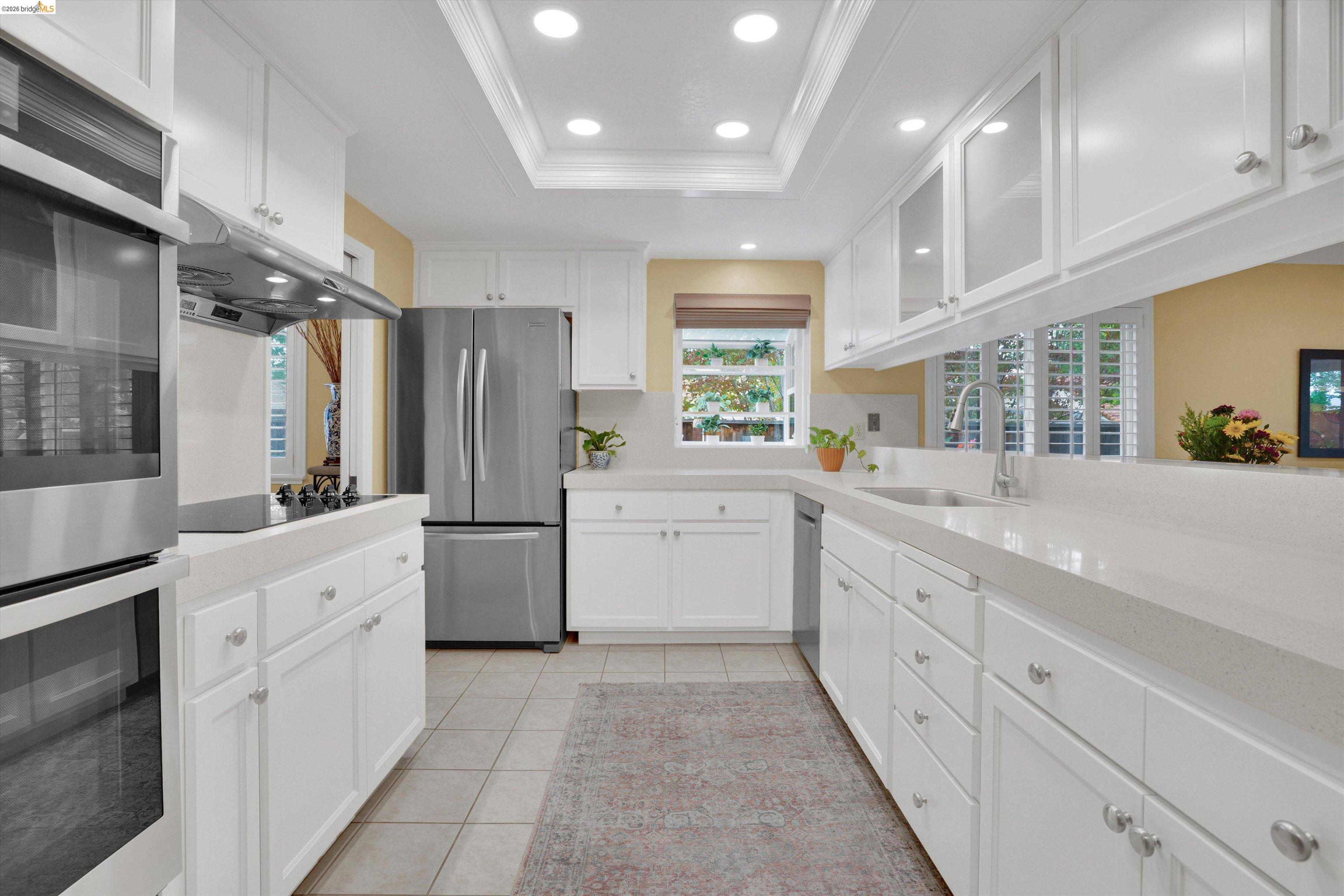 5001 St Garrett Court Concord, CA 94521 - Photo 23 of 45 Bright kitchen featuring extensive white cabinetry with brushed nickel hardware, light-toned countertops, and stainless steel appliances