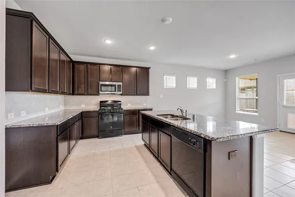 a kitchen with granite countertop stainless steel appliances and wooden cabinets