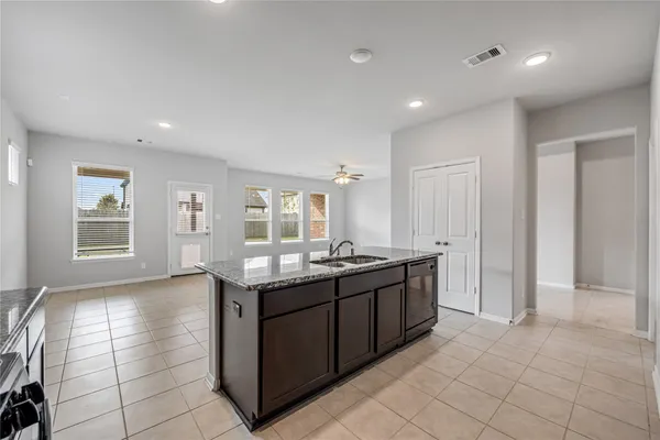 a kitchen with stainless steel appliances granite countertop a sink and a stove