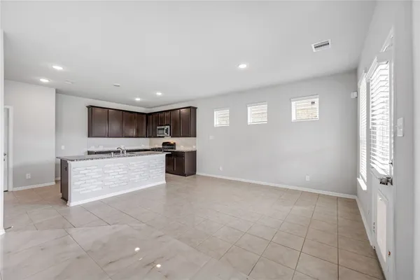 a large kitchen with a stove top oven and cabinets