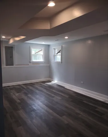 a view of an empty room with wooden floor and stairs