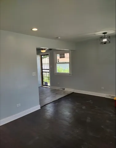 a kitchen with stainless steel appliances granite countertop a sink a stove top oven a chimney and a wooden floor