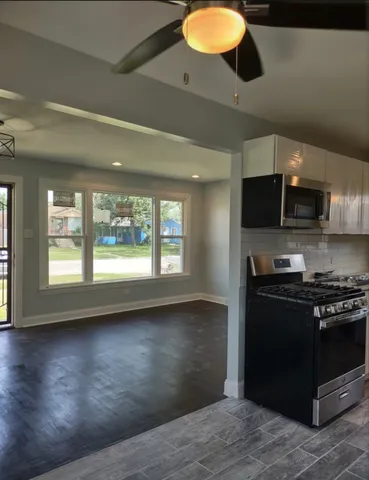 a kitchen with stainless steel appliances granite countertop a stove a sink and a refrigerator