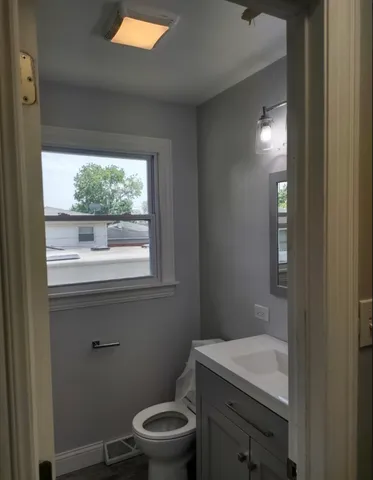 an empty room with wooden floor closet and windows